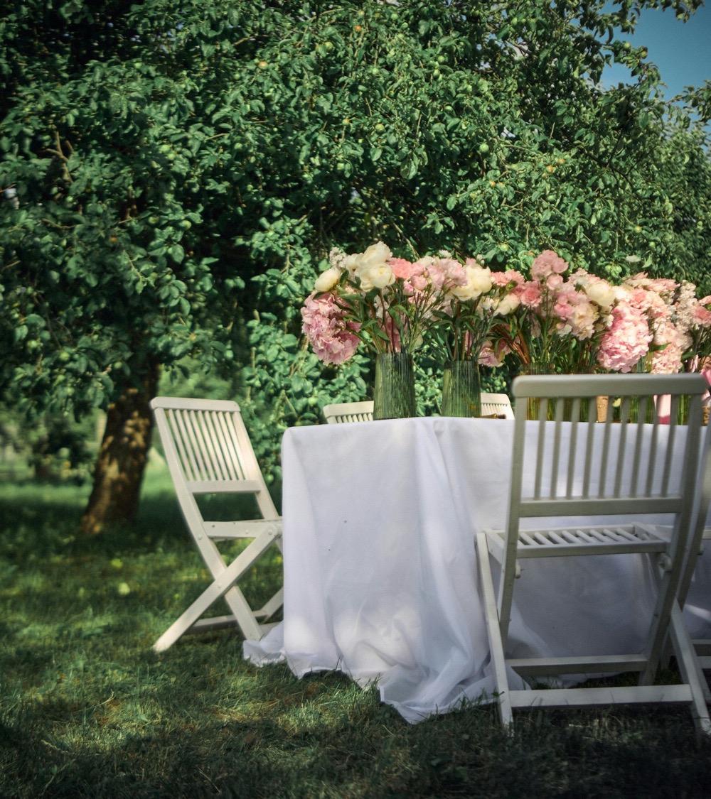 Tuintafel met bloemstuk in het groen