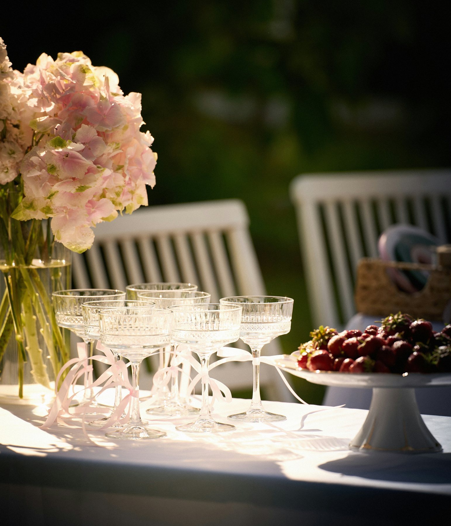 Zomerse tafelstyling met bloemen, glaswerk en taart